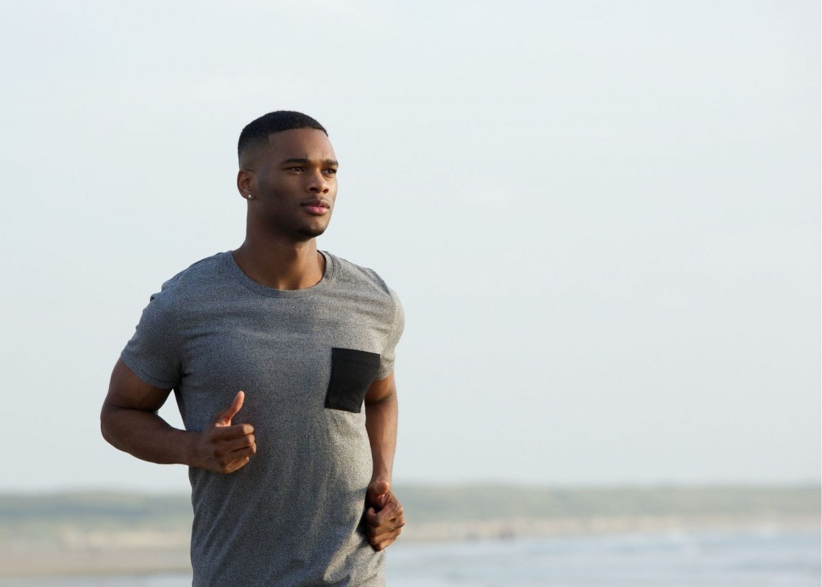 Man running on beach to start his fitness journey